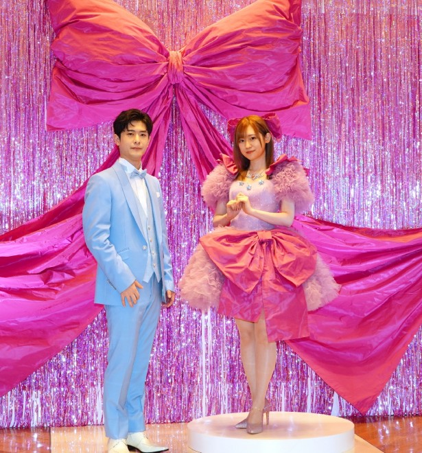 Takeo Ōtsuka and Rie Takahashi appear in outfits inspired by Aqua and Ai respectively, at the KIYOKO HATA × Oshi no Ko dress collection press conference in Tokyo. Takahashi stuns in a pink frilly dress with a large ribbon, while Ōtsuka wears an elegant aqua-blue tuxedo.